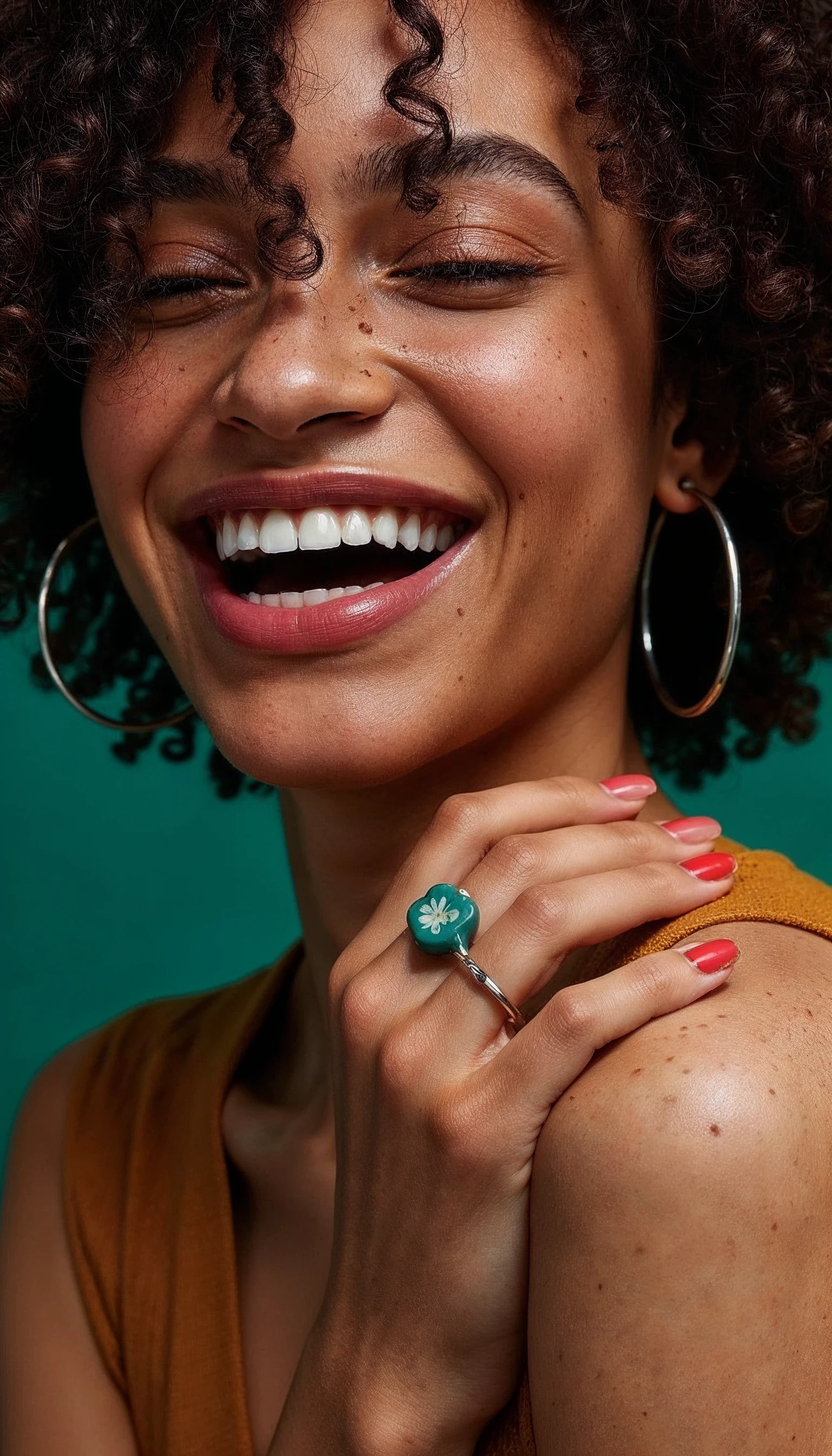 Smiling woman with curly hair against a teal backdrop, LifeMD brand photography