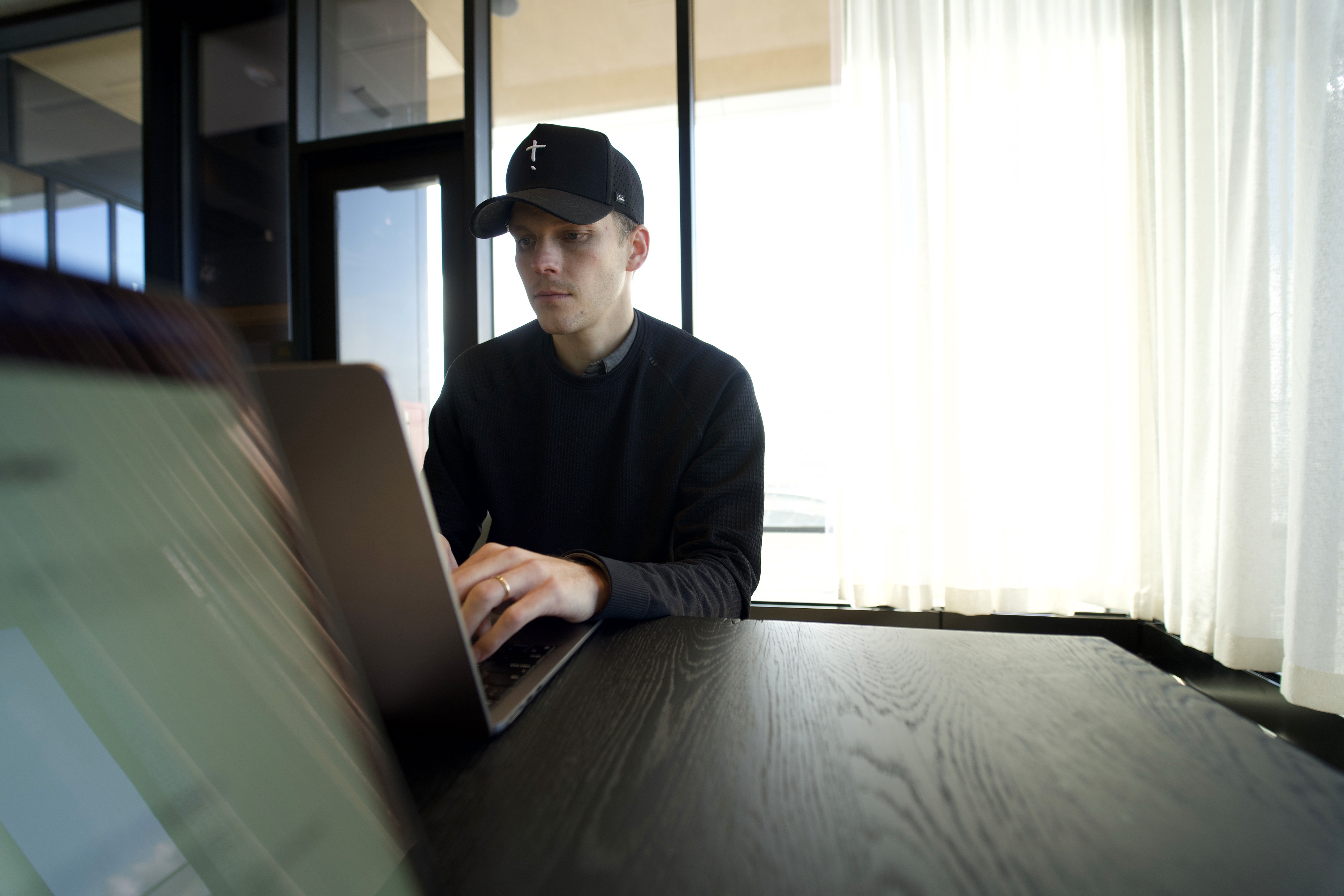 Upstory designer working on a laptop by a bright window