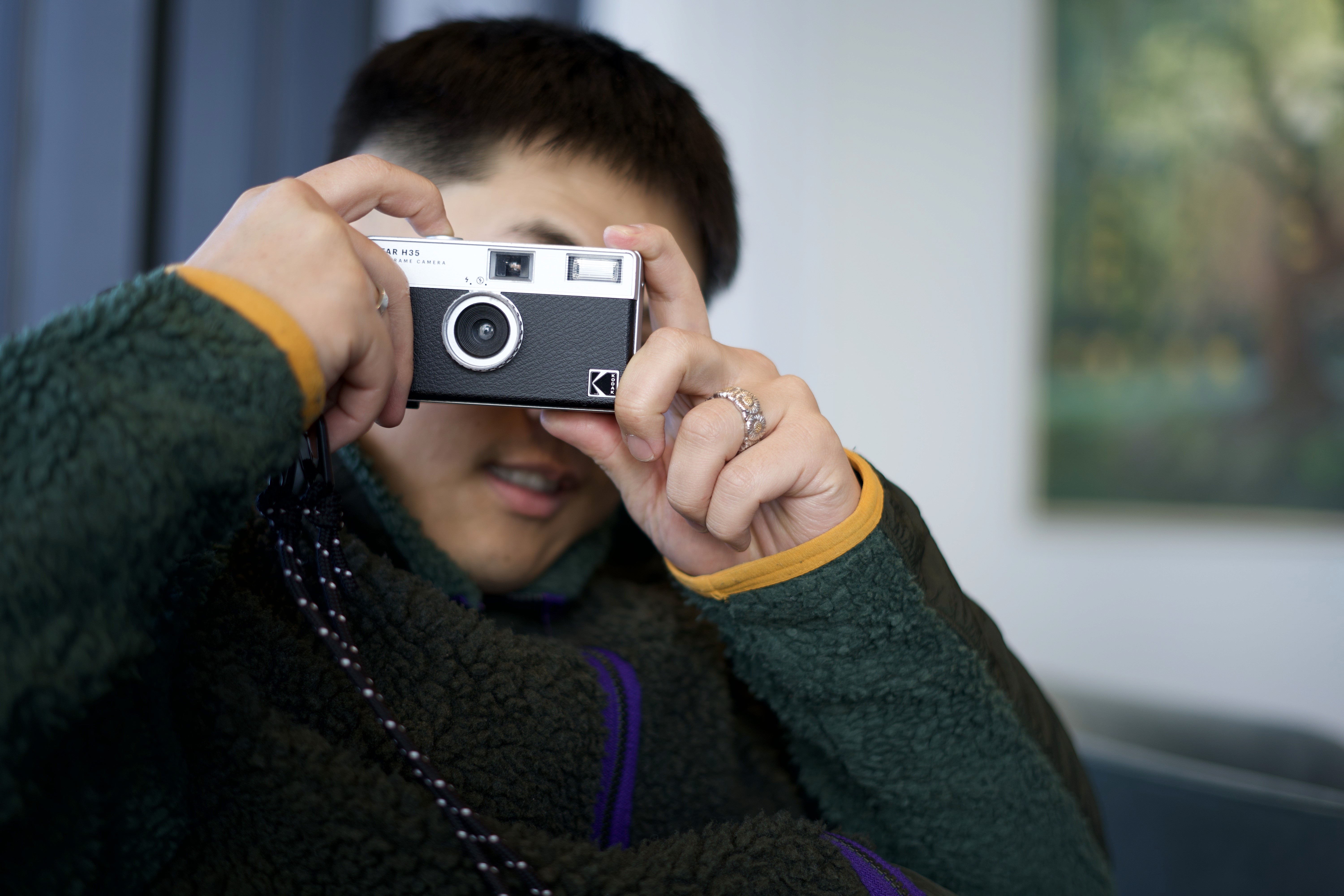 Upstory team member taking a photo with a film camera